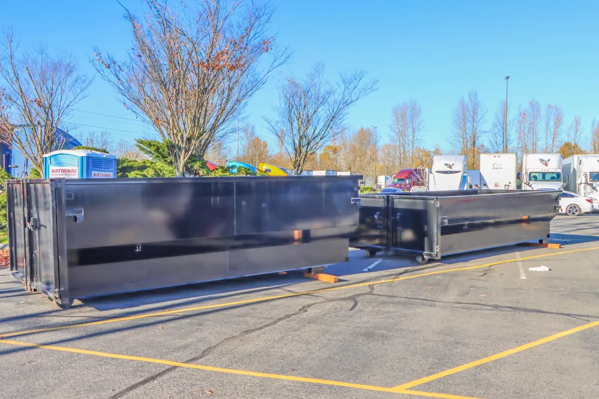 Professional dumpster rental service with roll-off container on residential driveway in Bucksport